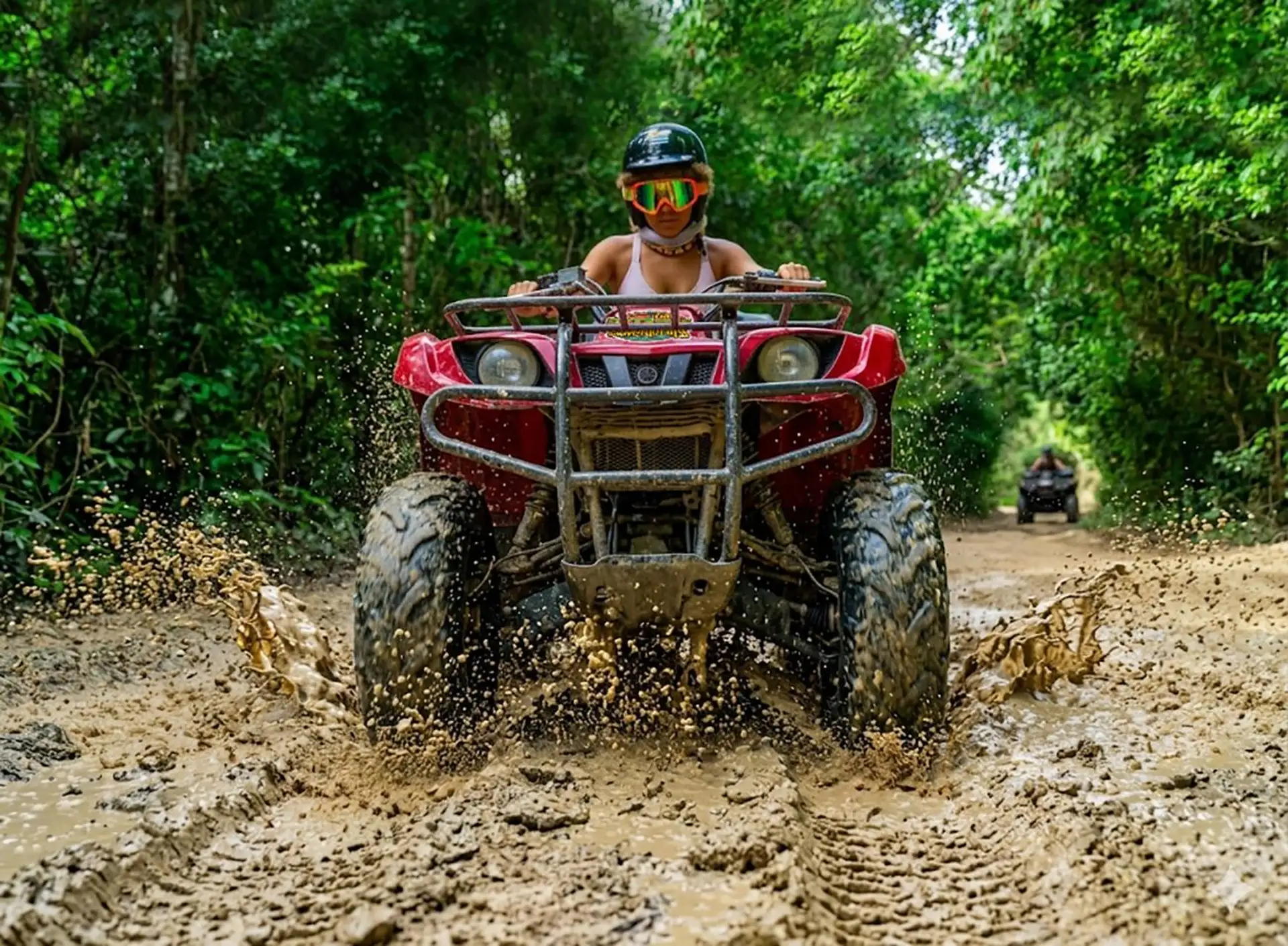 Helmeted ATV rider on a muddy jungle trail, from the Extreme Adventure listing